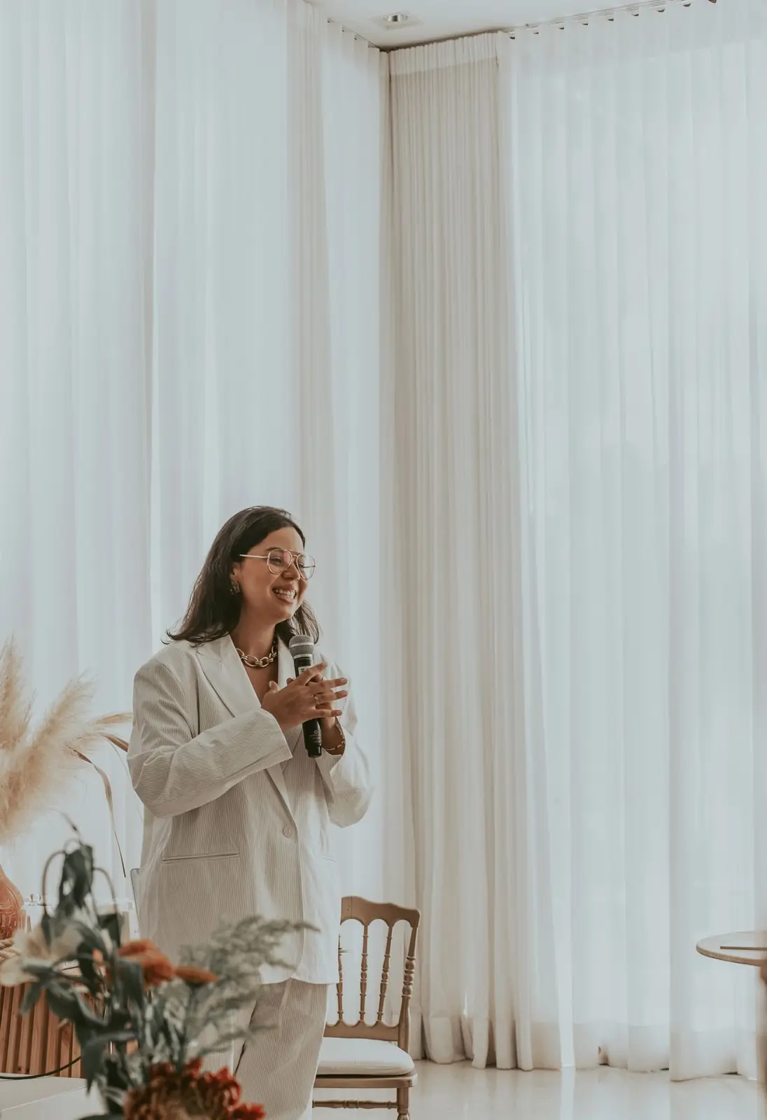 Bruna falando ao microfone em um encontro