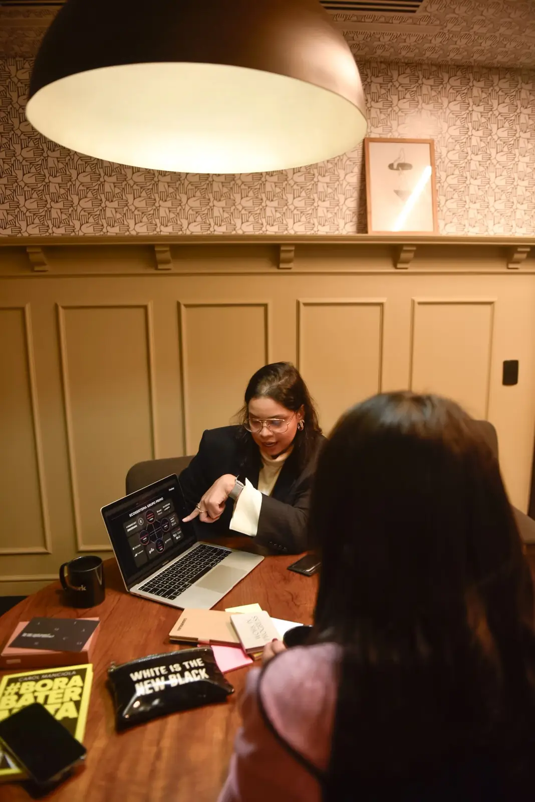 Bruna trabalhando ao notebook com uma cliente